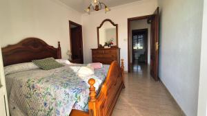 a bedroom with a bed and a dresser and a mirror at Fogar do Faustino,Rianxo by Cristian&Tamara "alquileres" in Rianjo