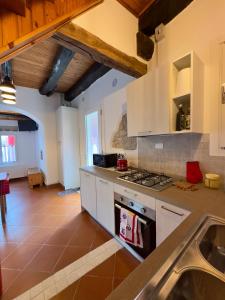 a kitchen with white cabinets and a stove top oven at Da Nonna Laura in Follina