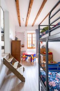 a room with two bunk beds and a table at B&B Des Histoires d'Anges - Côté Jardin - Accueil Vélo in Tournus
