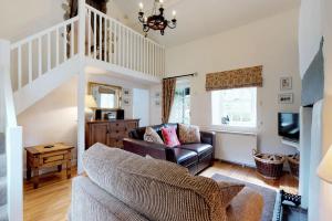 a living room with a couch and a tv at Pant Glas in Penmaen-mawr