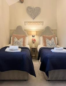 a bedroom with two beds and a heart on the wall at Bents Holiday Cottage, Views & Parking for two cars in Oxenhope