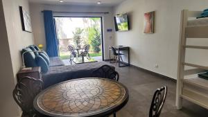 ein Wohnzimmer mit einem Tisch und einem Bett in der Unterkunft Hotel Oasis-Dream Holidays - La Petite France in San Bernardino