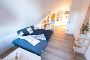 a bedroom with a blue bed and a staircase at Charmante Ferienwohnung mit sonniger Loggia in Celle