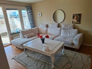 a living room with a white couch and a table at Villa Glumslov in Landskrona