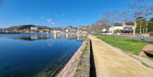 a river with a path next to a city at love room, sauna et balnéo in Perros-Guirec +10 photos