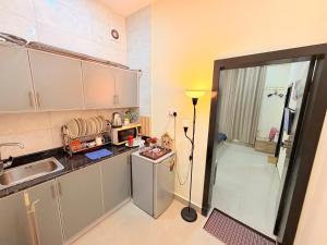 a small kitchen with a sink and a refrigerator at Modern Studios Apartments in Juffair and Exhibition in Manama
