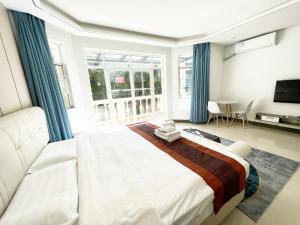 a bedroom with a large bed with blue curtains at Yalong Sea Joy in Sanya