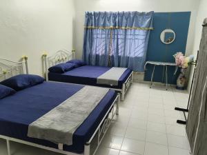 a room with two beds and a window at Raintown RR Homestay in Kamunting