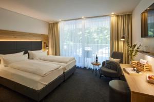 a hotel room with two beds and a desk and a desk at Wiedemann's Weinhotel in Sankt Martin +27 photos