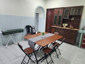 a dining room with a table and chairs at Raintown RR Homestay in Kamunting +5 photos