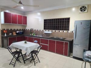 a kitchen with a table with chairs and a refrigerator at Raintown RR Homestay in Kamunting