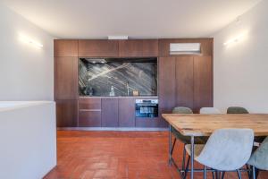 a kitchen with a wooden table and chairs at Flateli Santa Clara 22 in Girona