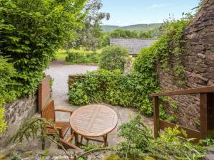 a patio with a wooden table and two chairs at Cleeve- Ukc4922 in Timberscombe