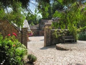 a garden with a bench and a stone wall at Cleeve- Ukc4922 in Timberscombe