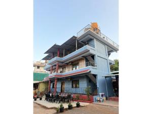 a blue building with tables in front of it at Green Leaf Mini Resort in Mahabaleshwar +6 photos