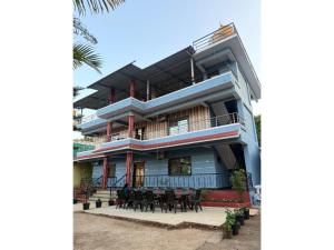 a building with tables and chairs in front of it at Green Leaf Mini Resort in Mahabaleshwar