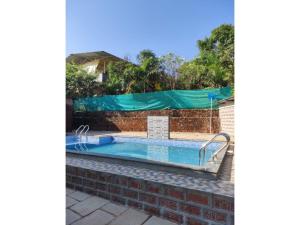 a swimming pool with a green tarp over it at Green Leaf Mini Resort in Mahabaleshwar