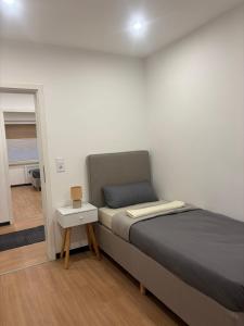 ein kleines Schlafzimmer mit einem Bett und einem kleinen Tisch in der Unterkunft WeserZeit Apartment in Bodenwerder + 5 Fotos
