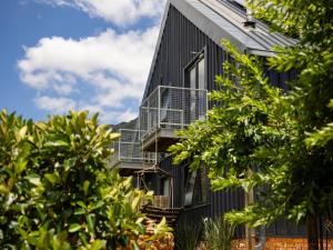a black house with two balconies and trees at Camissa Farm in Stellenbosch +8 photos