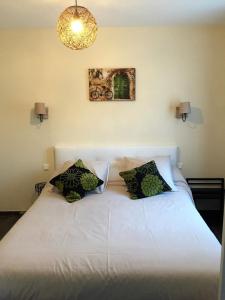 sypialnia z białym łóżkiem z 2 poduszkami w obiekcie Gîte de Roches Toucan w mieście Seigy