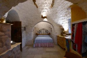 a bedroom with a bed in a stone wall at Trulli La Gufa in Ostuni