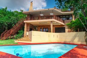 a house with a swimming pool in front of a house at The View Guesthouse in Nelspruit