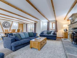 a living room with blue couches and a fireplace at Barn View in Clay Cross