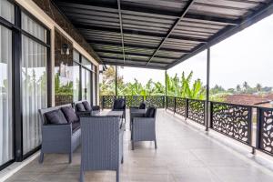 a patio with chairs and tables on a balcony at Spacious Tropical Villa with Pool and Bfast in Sleman