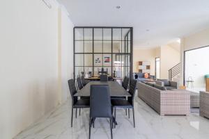 a dining room with a table and chairs and a couch at Spacious Tropical Villa with Pool and Bfast in Sleman
