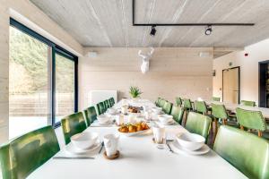 uma sala de jantar com uma mesa longa e cadeiras verdes em Daft Boutique Hotel & Glamping em Malmedy