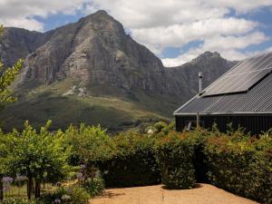 a house with a mountain in the background at Camissa Farm in Stellenbosch