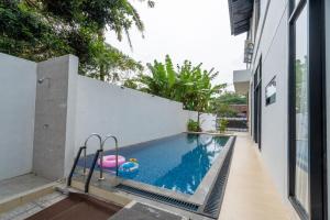 a swimming pool with a float in a house at Spacious Tropical Villa with Pool and Bfast in Sleman