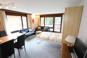 a living room with a bed and a dining room at Kontiki in Saas-Fee