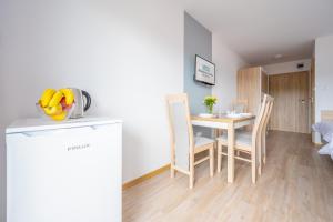 a kitchen and dining room with a table and chairs at Błękitna Fala Resort in Dąbki