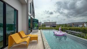 a swimming pool with a swan in the middle of a house at Gaia Pool Villa Khao Yai in Ban Bung Toei