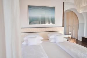 a white bed with white pillows and a picture on the wall at Hotel Hirschen in Freiburg-Lehen in Freiburg im Breisgau