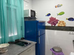 a kitchen with a blue refrigerator in a room at Apartamento Pacífico in Chipiona