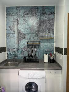 a washing machine in a kitchen next to a sink at Apartamento Pacífico in Chipiona