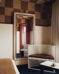 ein Spiegel in einem Zimmer mit einem Bett und einem Tisch in der Unterkunft Hôtel Luxia & Spa in Paris