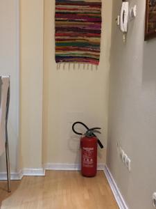 a red trash can in a hallway with a towel on the wall at AMN Center Apartment in Belgrade