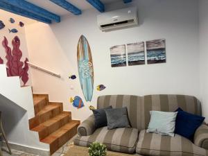 a living room with two couches and a surfboard on the wall at Apartamento Pacífico in Chipiona