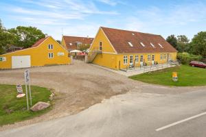 a large yellow house with a road in front of it at Boeslunde Bed & Breakfast in Boeslunde