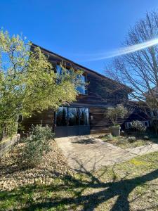a wooden house with a driveway in front of it at Loft Bike & Chill Mont Ventoux - Jacuzzi - Local vélos in Entrechaux