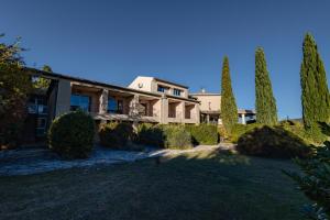 an exterior view of a house with cypress trees at Hotel Bellerive in Rasteau +28 photos