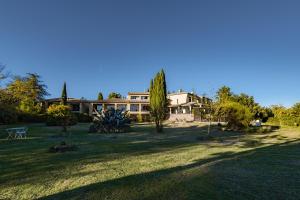 a large house in a yard with trees and a field at Hotel Bellerive in Rasteau