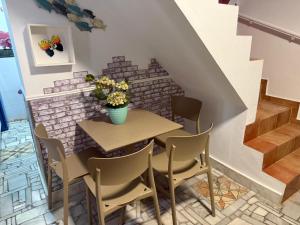a table with chairs and a vase of flowers at Apartamento Pacífico in Chipiona +22 photos