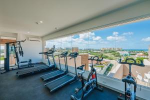 a gym with treadmills and ellipticals in a building at Aracari Residences by Bocobay - Luxury Condos 5 min Walk to Ritz and Palm Beach in Palm-Eagle Beach