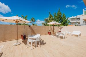 a patio with tables and chairs and umbrellas at Aracari Residences by Bocobay - Luxury Condos 5 min Walk to Ritz and Palm Beach in Palm-Eagle Beach