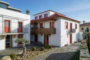 a white house with red doors and balconies at Casa Dr Ramiro Salgado - Douro Superior, Torre de Moncorvo in Torre de Moncorvo