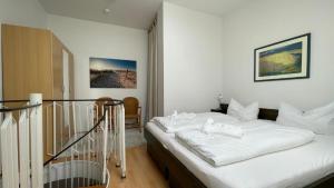 a bedroom with a bed with white sheets on it at Accumer EE in Langeoog